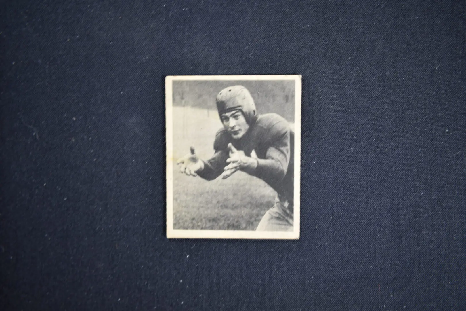 A black and white photo of an old football player.