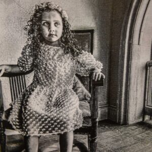 A young girl sitting in a rocking chair.