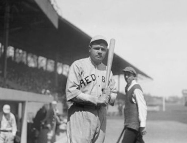 A baseball player holding a bat in front of an audience.