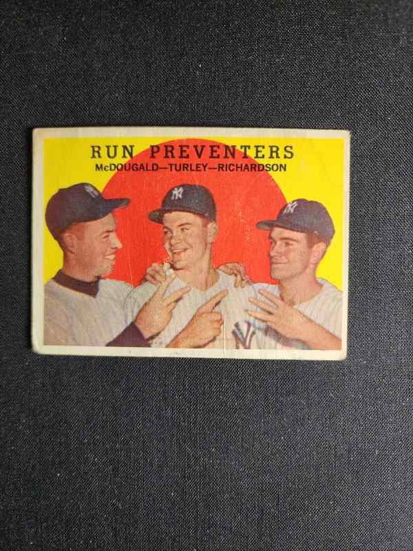 A baseball card with three players on it.