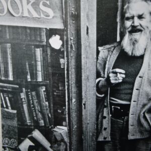 A man standing in front of a book store.