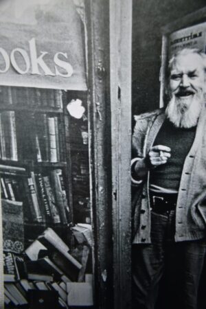 A man standing in front of a book store.