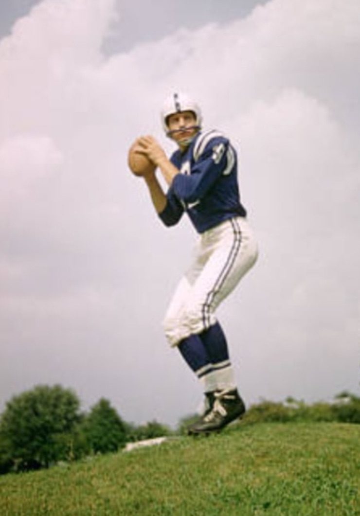 A man in blue and white football uniform holding a ball.