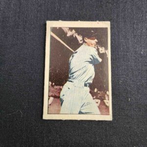 A baseball player is holding his bat and smiling.