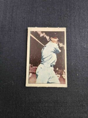 A baseball player is holding his bat and smiling.