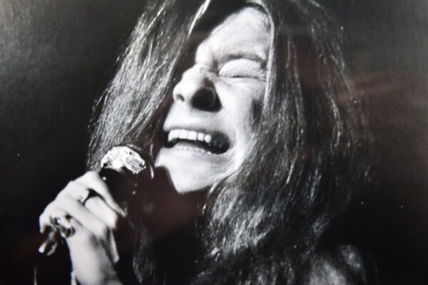 A woman with long hair is singing into a microphone.