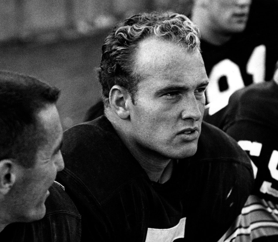 A black and white photo of two men sitting next to each other.