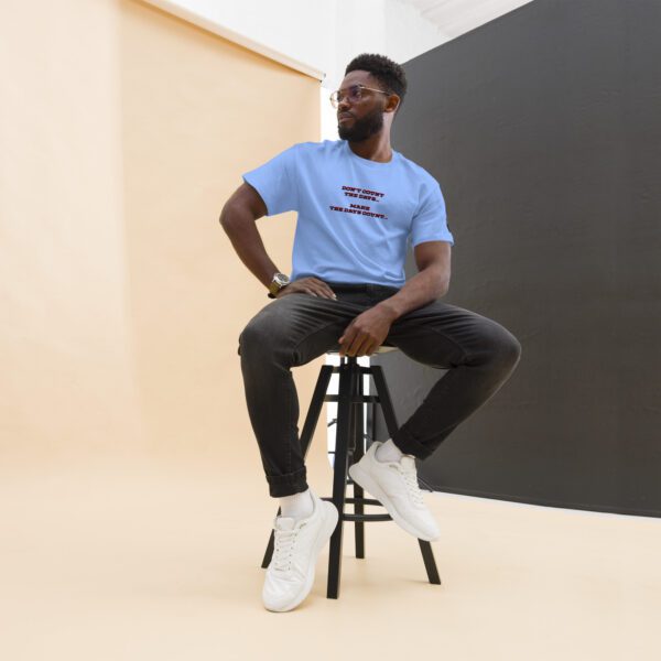 A man sitting on top of a stool wearing white shoes.