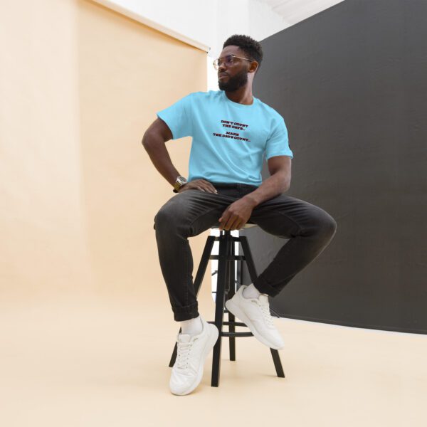 A man sitting on top of a stool wearing white shoes.