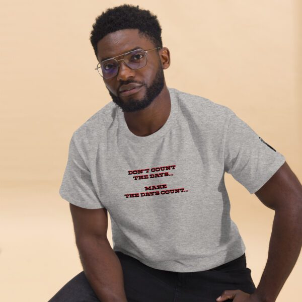 A man in glasses and a t-shirt is sitting on the ground