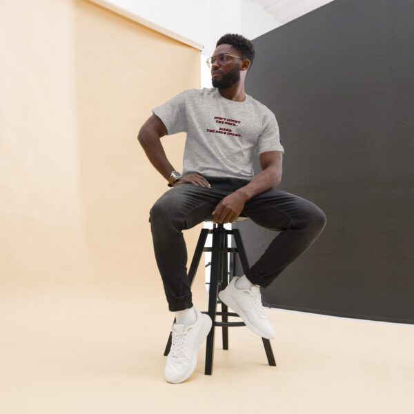 A man sitting on top of a stool in front of a wall.