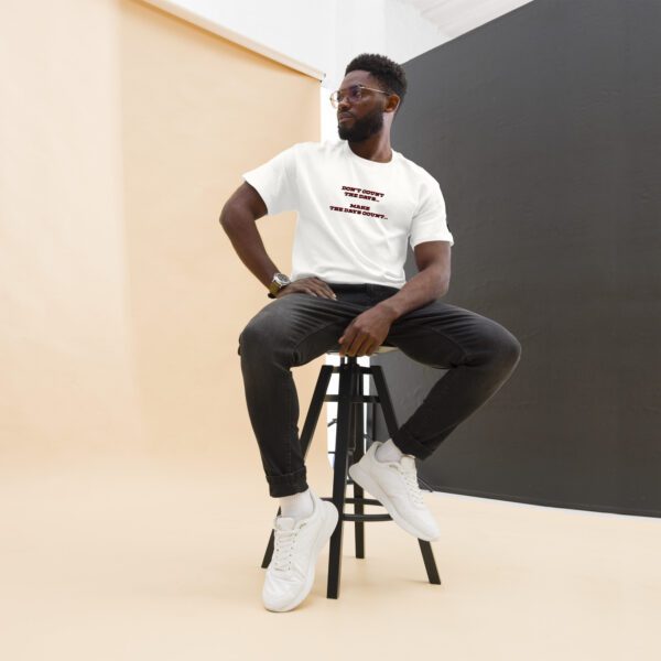 A man sitting on top of a stool in front of a wall.