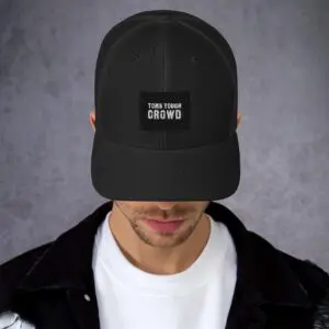 A man wearing a black hat with the words " you can 't grow " on it.