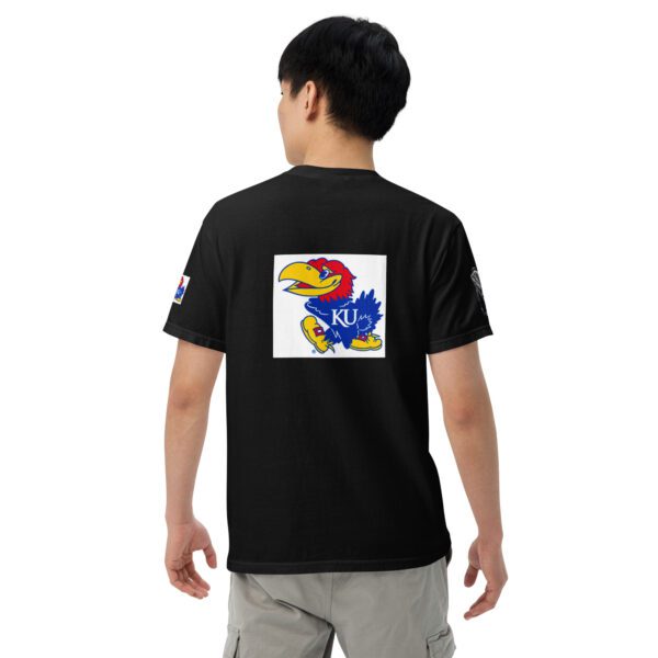 A boy wearing a black shirt with a blue, yellow and red bird on it.