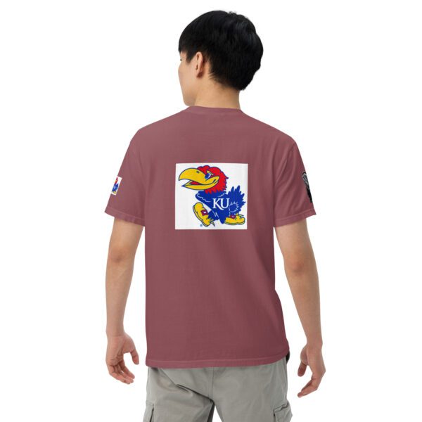 A person wearing a maroon shirt with an image of a bird on it.