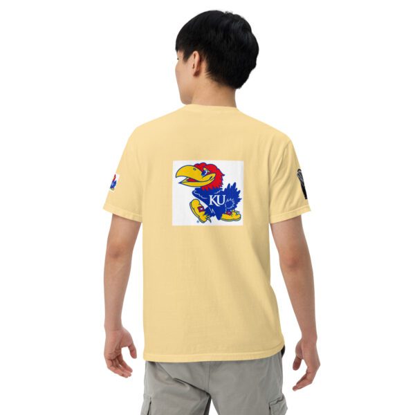 A person wearing a yellow shirt with an image of a bird on it.