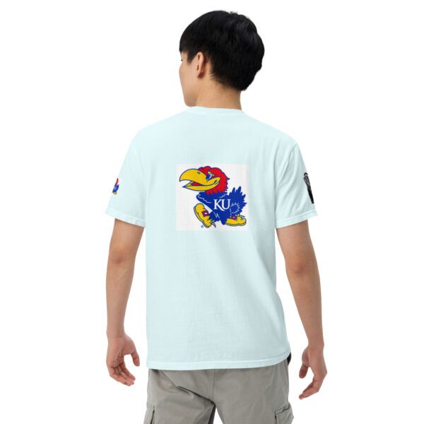 A boy wearing a light blue shirt with an image of the kansas jayhawks on it.