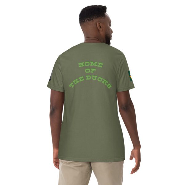 A man wearing a green shirt with the words home of the ducks on it.