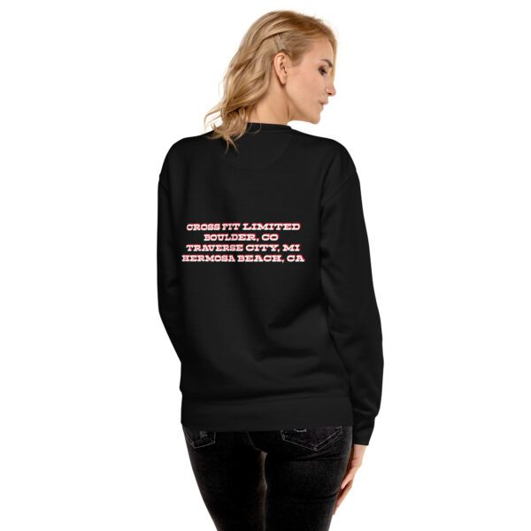 A woman wearing a black sweatshirt with pink writing on it.