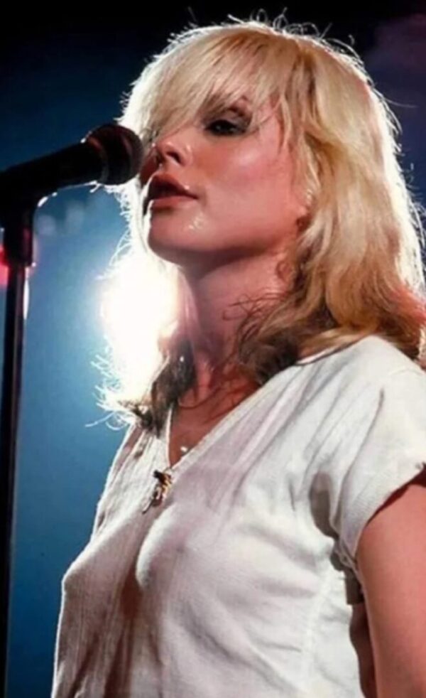 Woman with blonde hair singing into a microphone.