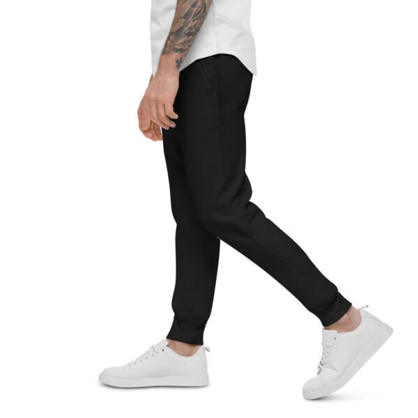 A man walking in white sneakers and black pants.