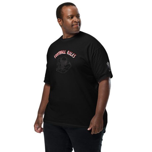 A man standing in front of the camera wearing black pants and a t-shirt.