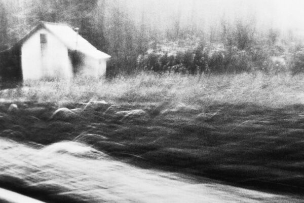 Black and white photo of a house in a field.