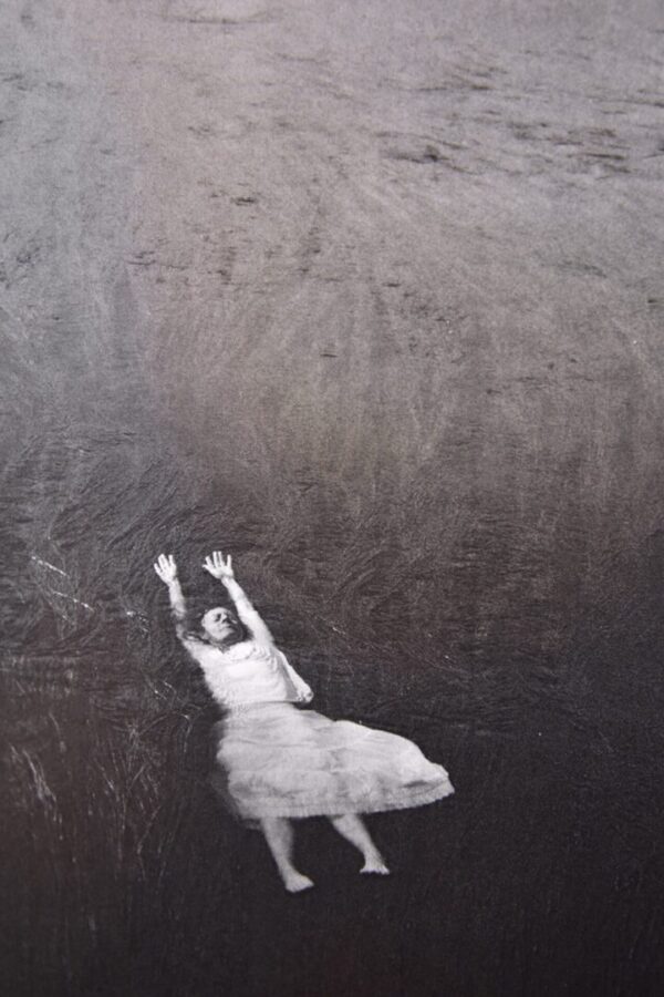 Woman in white dress falling backwards.