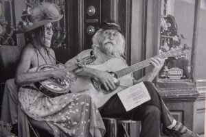 Two musicians playing guitars on street.