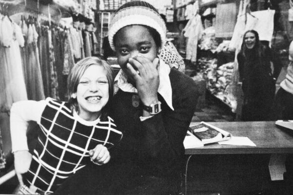 Two girls smiling in black and white.