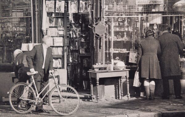 Black and white photo of a shop and people.