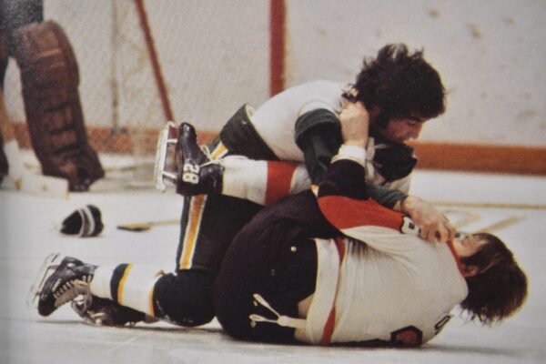 Two hockey players fight on the ice.