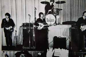 The Beatles performing live on stage.