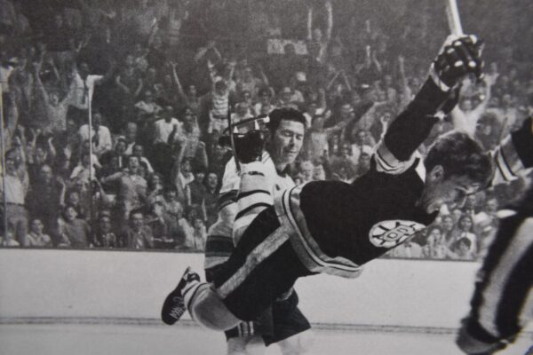 Hockey player scores in front of crowd.