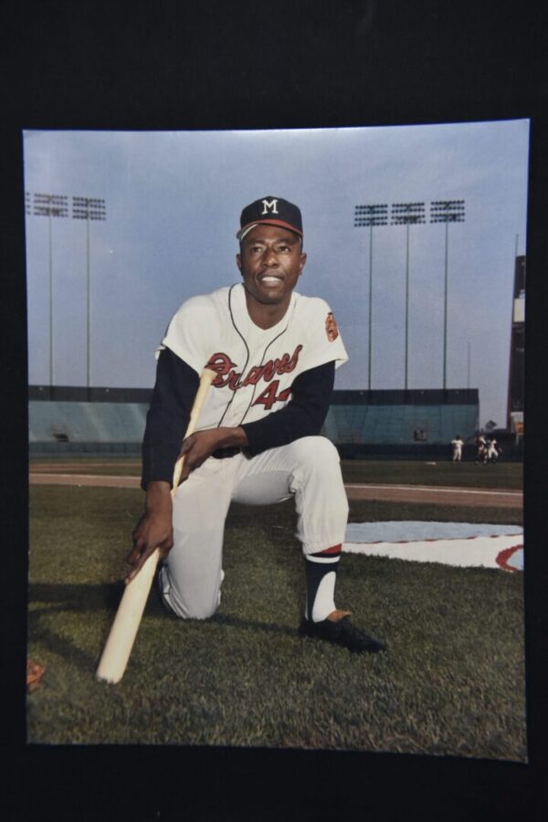 A baseball player kneeling with a bat.