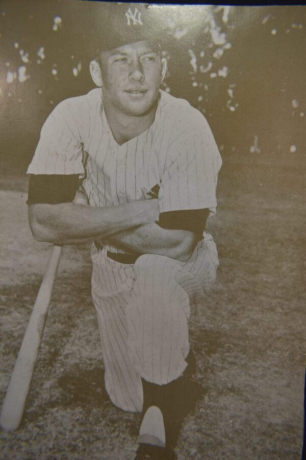 Baseball player kneeling with bat