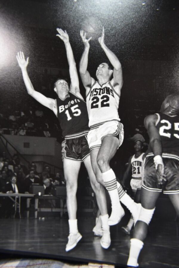 Basketball game, players jump for ball.