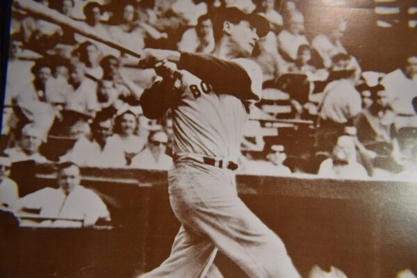 Baseball player swinging bat in stadium.