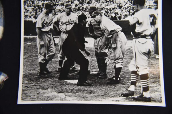 Black and white photo of baseball players and umpire.