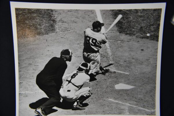 Baseball player batting with catcher and umpire.