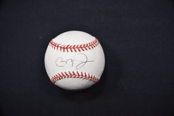 Signed baseball on black background.