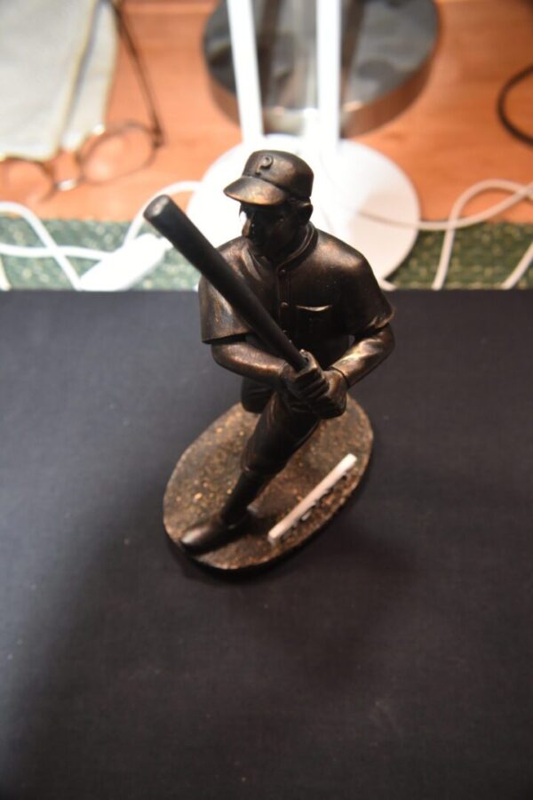 Bronze baseball player statue with bat.