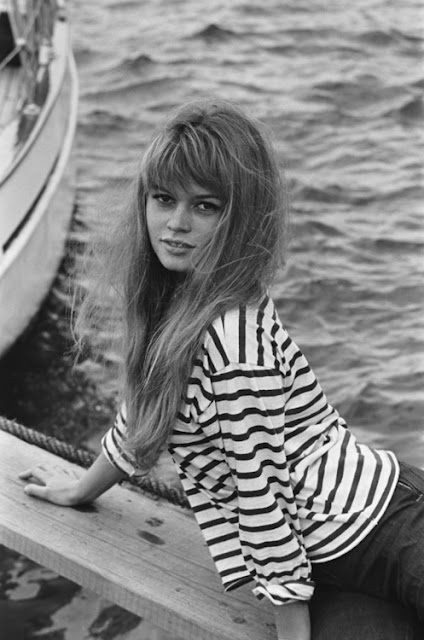 Woman in striped shirt by the water.