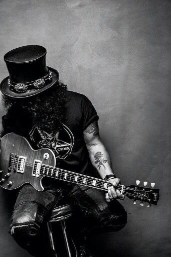 Black and white photo of Slash playing guitar.