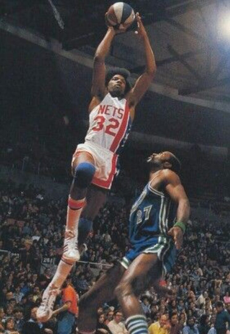 Nets player shooting over opponent.