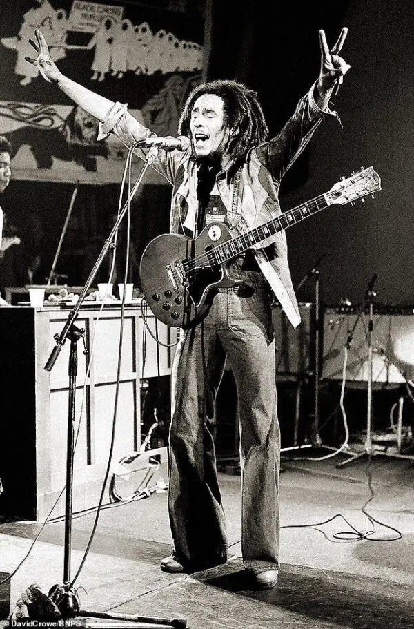 Bob Marley performing with a guitar.